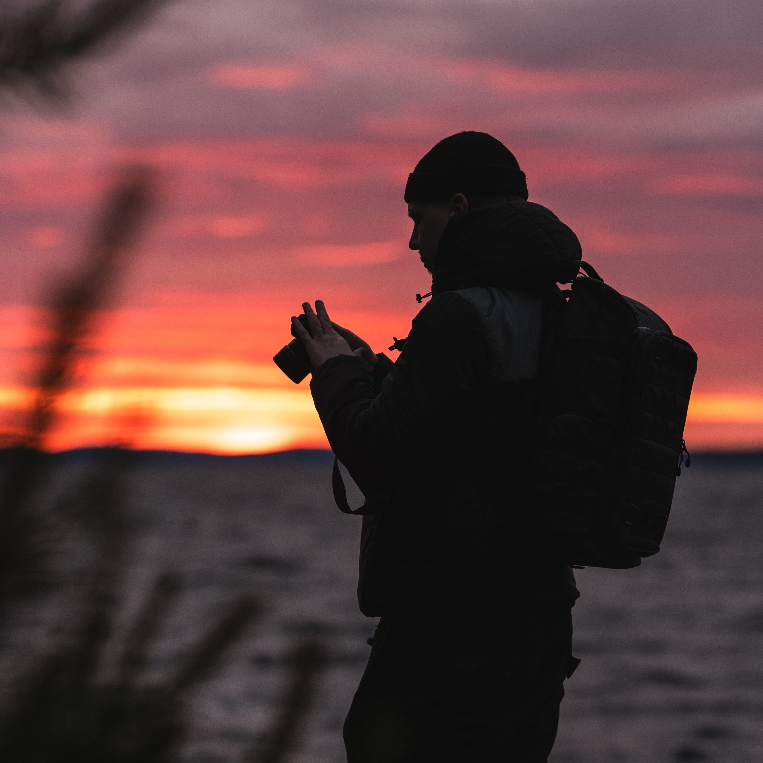 Silhouette of a photographer against a colorful sunset sky